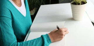 Person writing on notepad