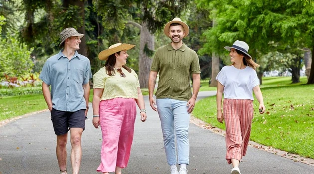 two men and two women walking in a park