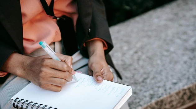 Person writing in notebook