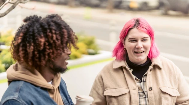 two friends having coffee smiling