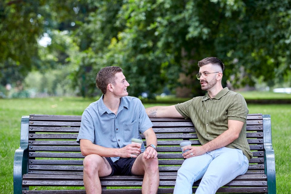 Friends on park bench having coffee