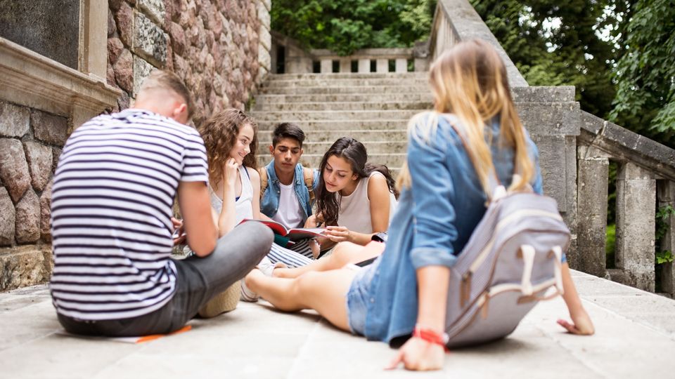 group of teenagers sitting in circle on steps