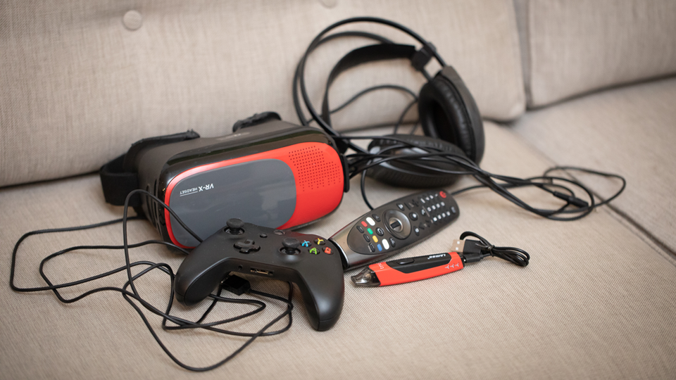 A vape that looks like a USB stick next to gaming equipment.